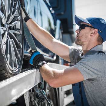 Soccorritore-stradale-che-fissa-auto-sul-carro-attrezzi-con-cinghie